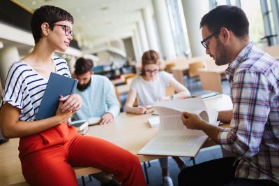 Group of college students studying at the library